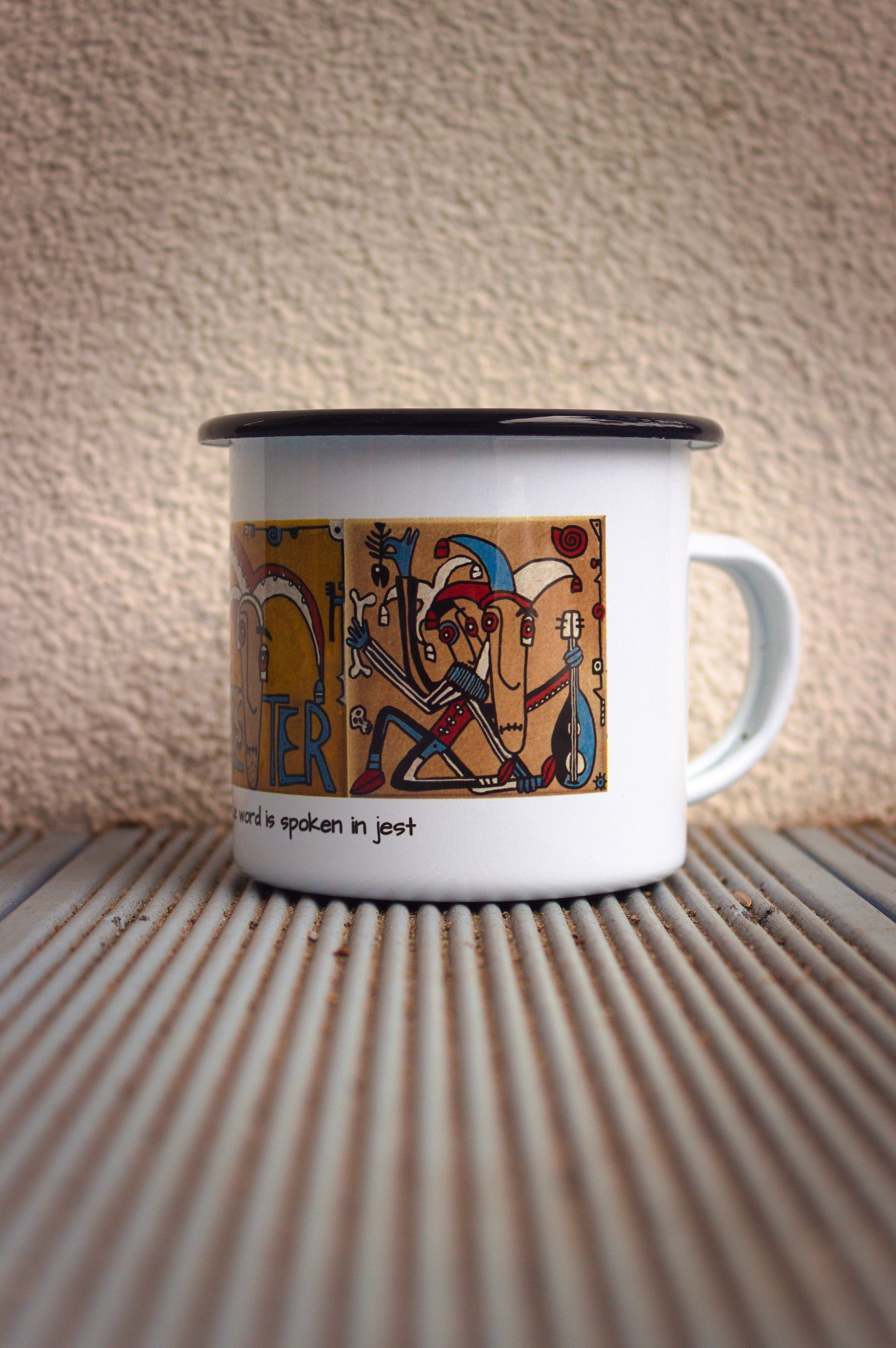 Stalowy kubek podróżniczy z czarnym rantem i grafiką inspirowaną tradycyjnym malarstwem na kafle, widok z prawej strony.